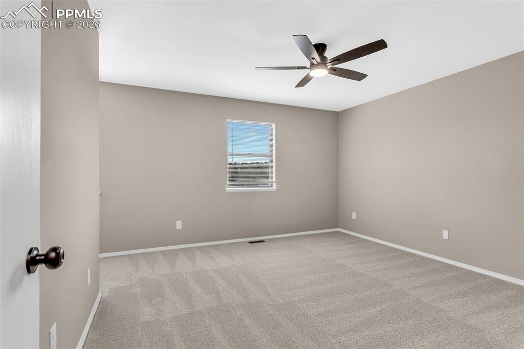 Image 22 of 30: Unfurnished room with a ceiling fan and light colored carpet