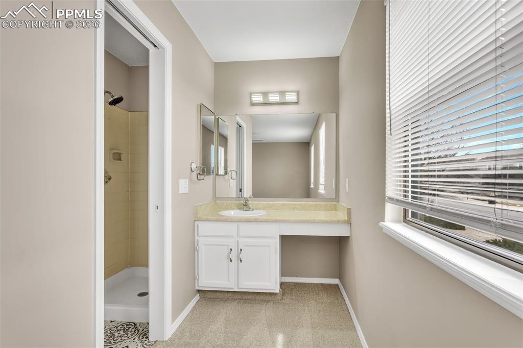 Image 24 of 30: Bathroom featuring vanity, a stall shower, and plenty of natural light