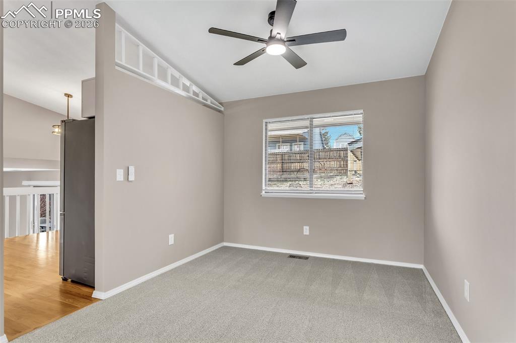 Image 5 of 30: Empty room featuring light colored carpet, a ceiling fan, and vaulted ceili