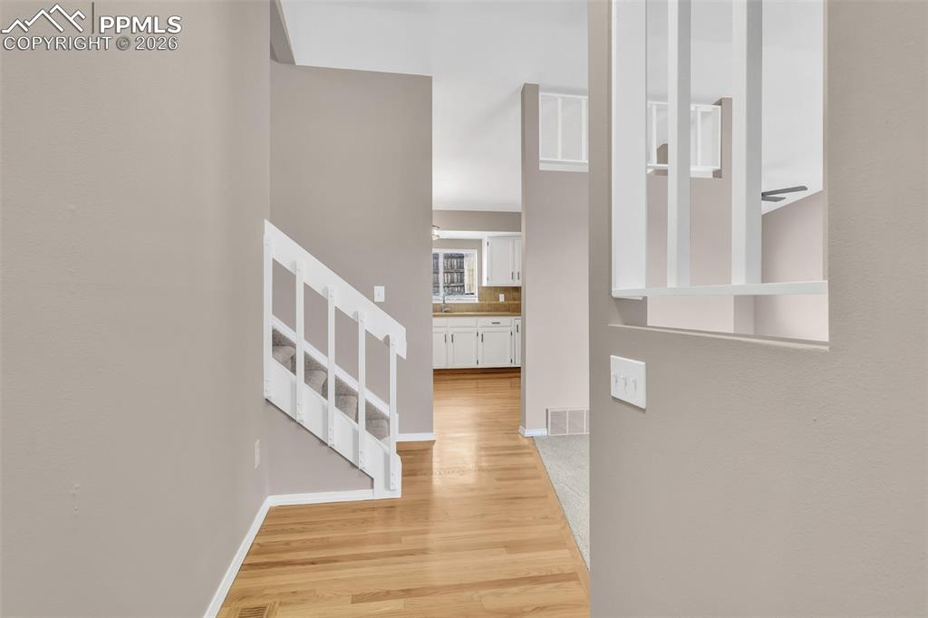 Image 6 of 30: Hallway featuring light wood finished floors and stairway