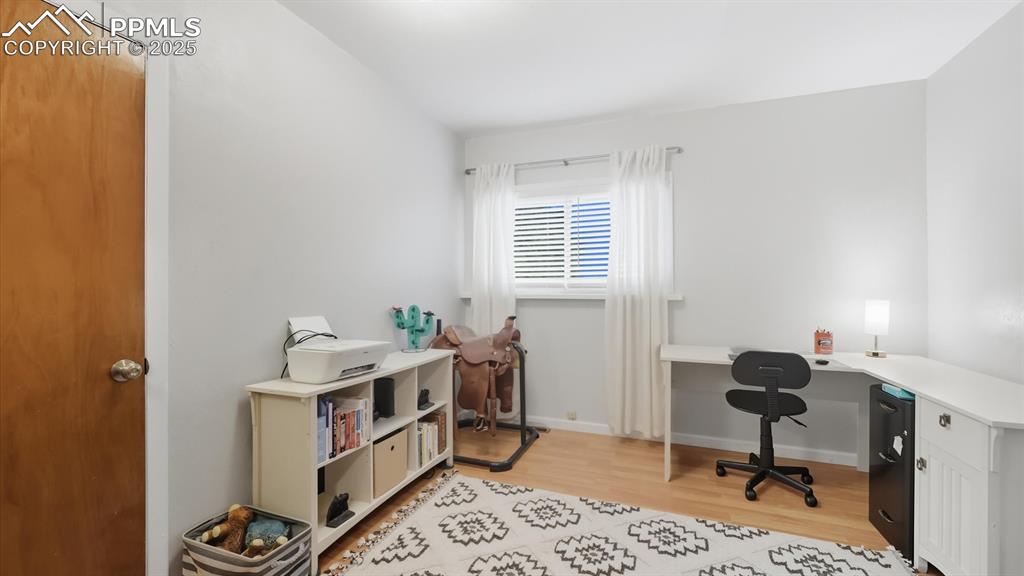 Image 23 of 34: Bedroom #1 (currently used as an office) with wood laminate floor and close