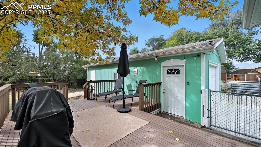 Image 32 of 34: Large composite deck with access to the 1-car detached garage and stairs to