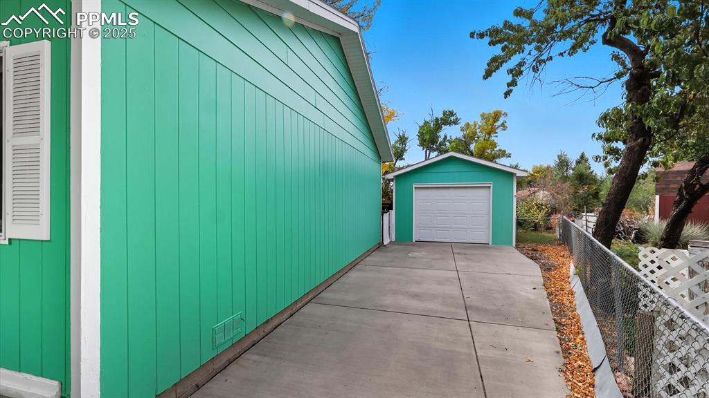 Image 6 of 34: Single detached garage with workshop + additional carport for parking.