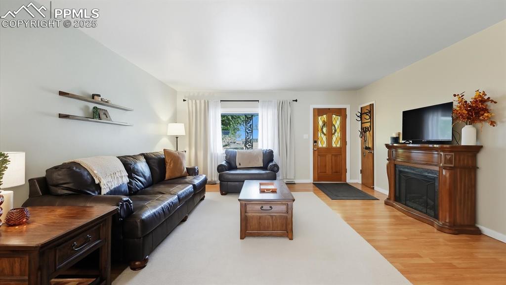 Image 9 of 34: The spacious Living Room has wood laminate floors and a large view window t