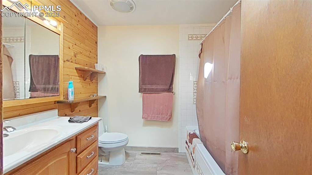 Image 13 of 25: Full bathroom featuring vanity, shower / bathtub combination with curtain,