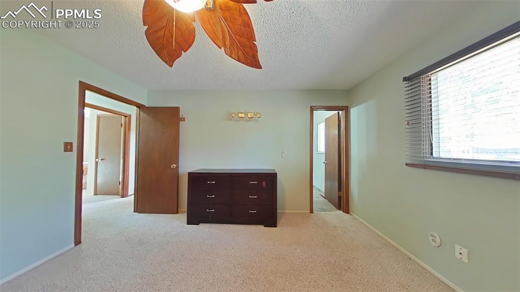 Image 15 of 25: Primary Bedroom featuring a textured ceiling and light colored carpet