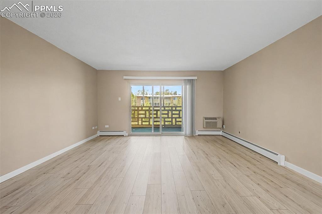 Image 10 of 42: Spacious interior featuring wood-finish flooring and neutral wall tones