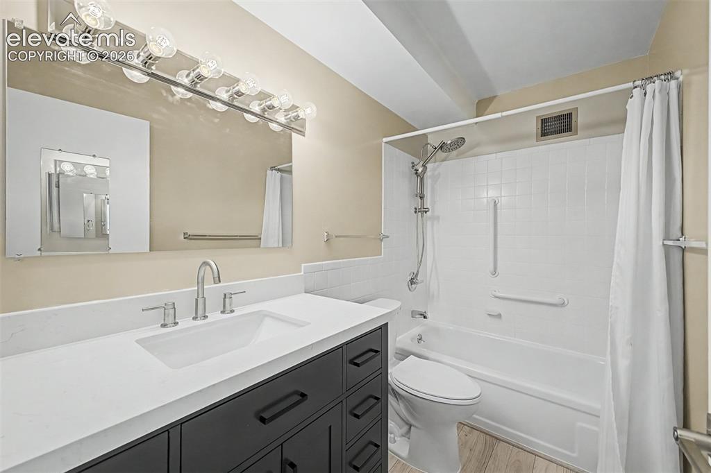 Image 17 of 50: Bathroom featuring a dark wood-finish vanity with a white countertop and an