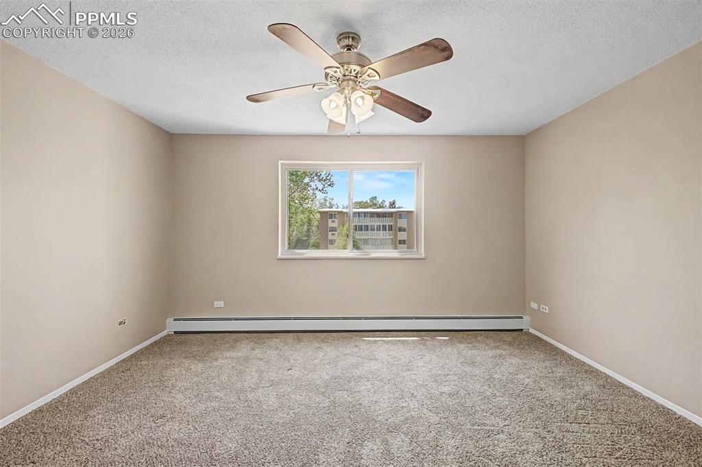 Image 18 of 42: Neutral tone wall paint, textured ceiling, and a ceiling fan with integrate