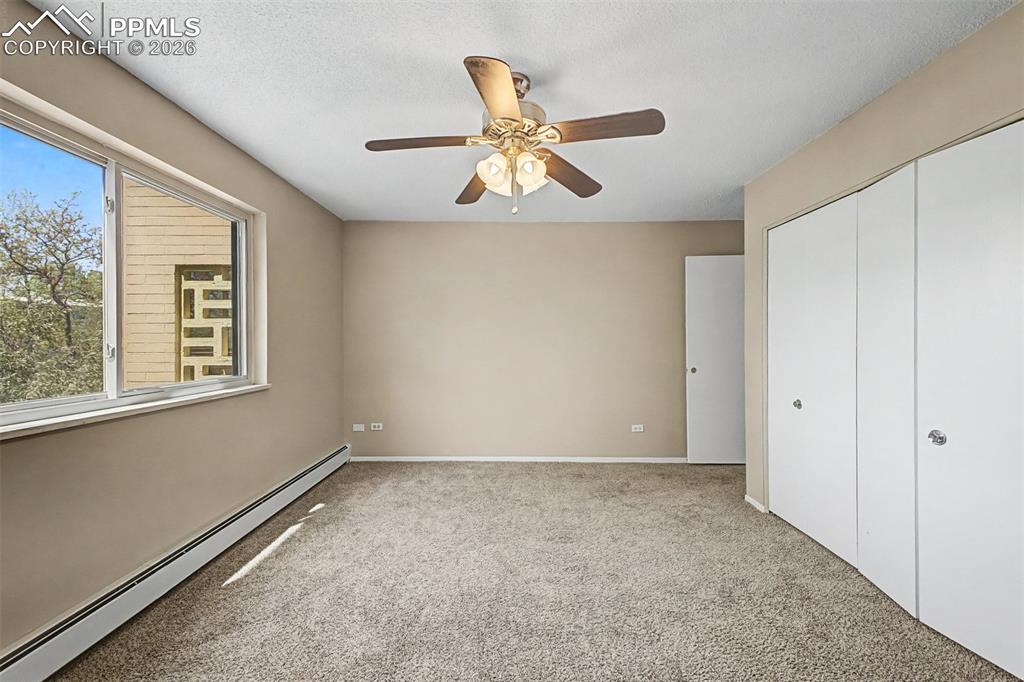 Image 19 of 42: Carpeted room with a multi-pane window, flush-mounted ceiling fan, and buil
