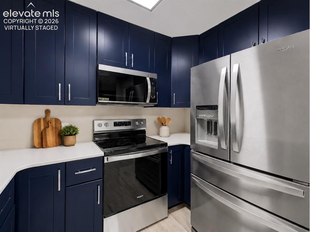 Image 2 of 50: virtually staged Contemporary kitchen featuring dark blue cabinetry with br