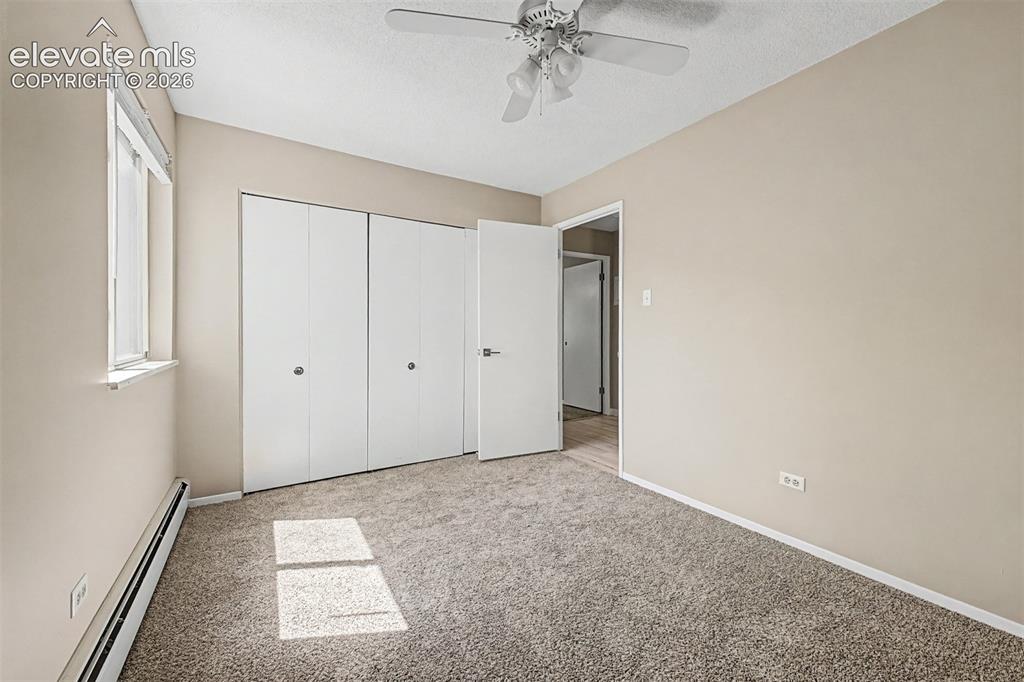 Image 23 of 50: Neutral-toned room featuring a window with white trim, built-in bi-fold clo