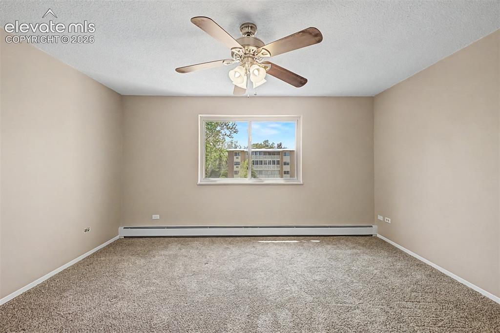Image 24 of 50: Neutral tone wall paint, textured ceiling, and a ceiling fan with integrate
