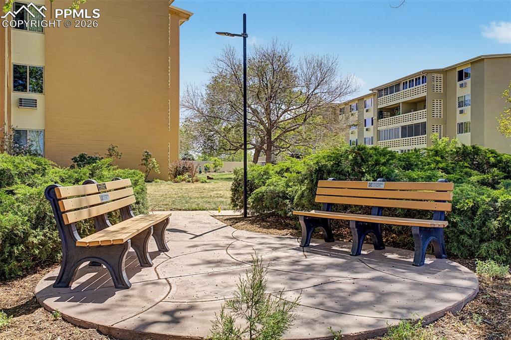 Image 25 of 42: Outdoor seating area featuring two benches with wood-finish slats and dark 
