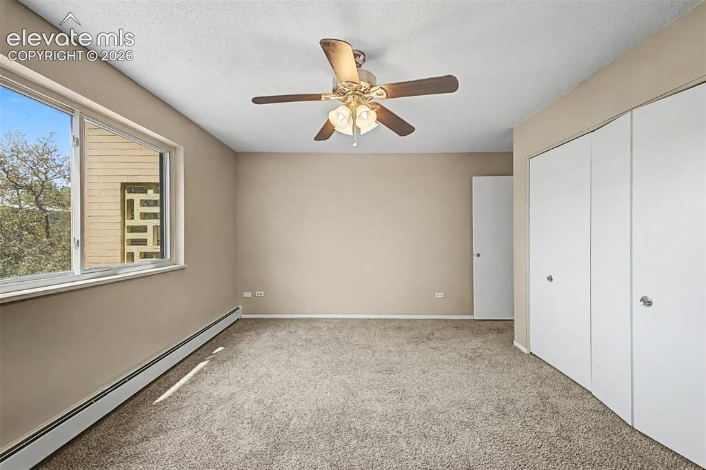 Image 25 of 50: Carpeted room with a multi-pane window, flush-mounted ceiling fan, and buil