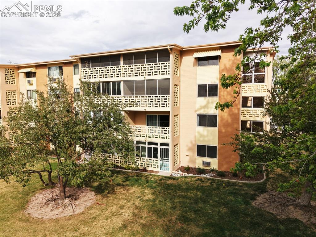 Image 27 of 42: Multi-story building exterior featuring brick and stucco finishes, multiple