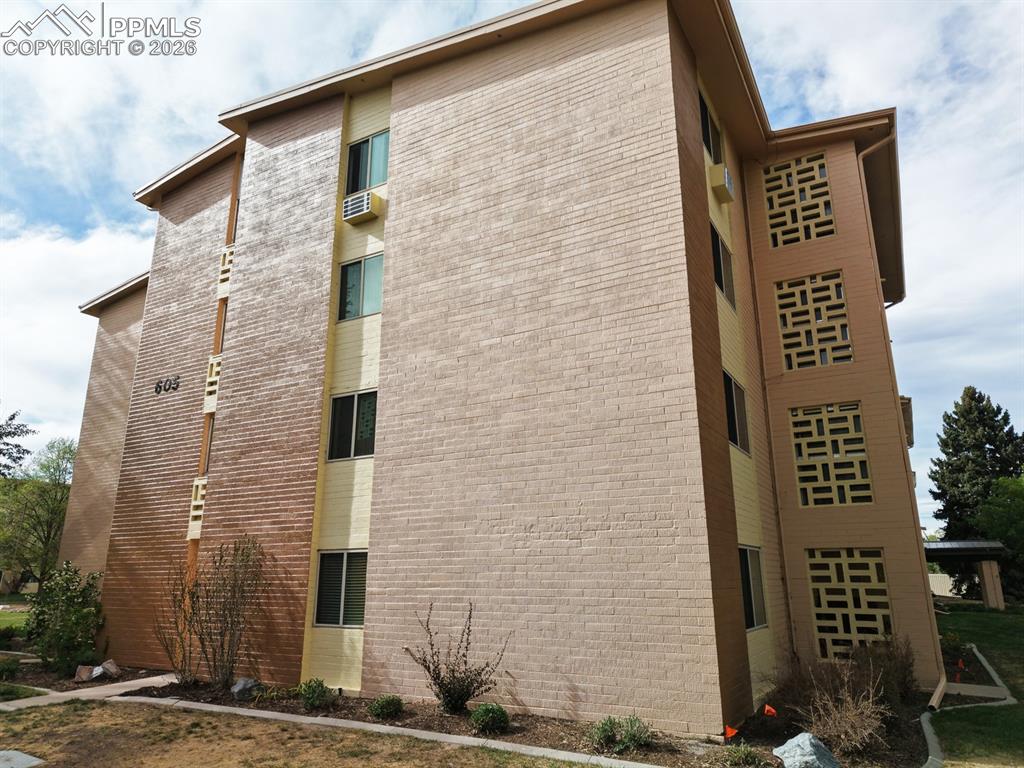 Image 28 of 42: Multi-story building featuring brick and stucco exterior construction
