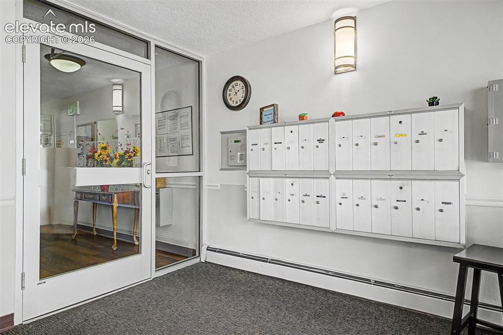 Image 28 of 50: Entryway featuring secured mailboxes and a glass-paneled access door