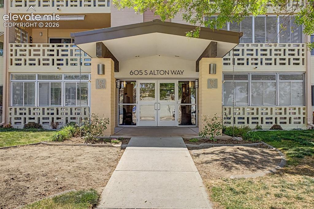 Image 31 of 50: Building entrance featuring an overhead canopy, double glass doors, and ext