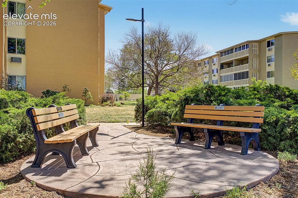 Image 34 of 50: Outdoor seating area featuring two benches with wood-finish slats and dark