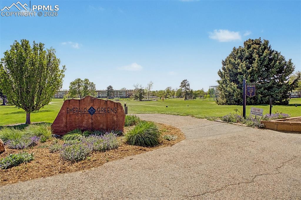 Image 35 of 42: Emerald Greens Golf Club entrance with a stone monument sign, surrounded by