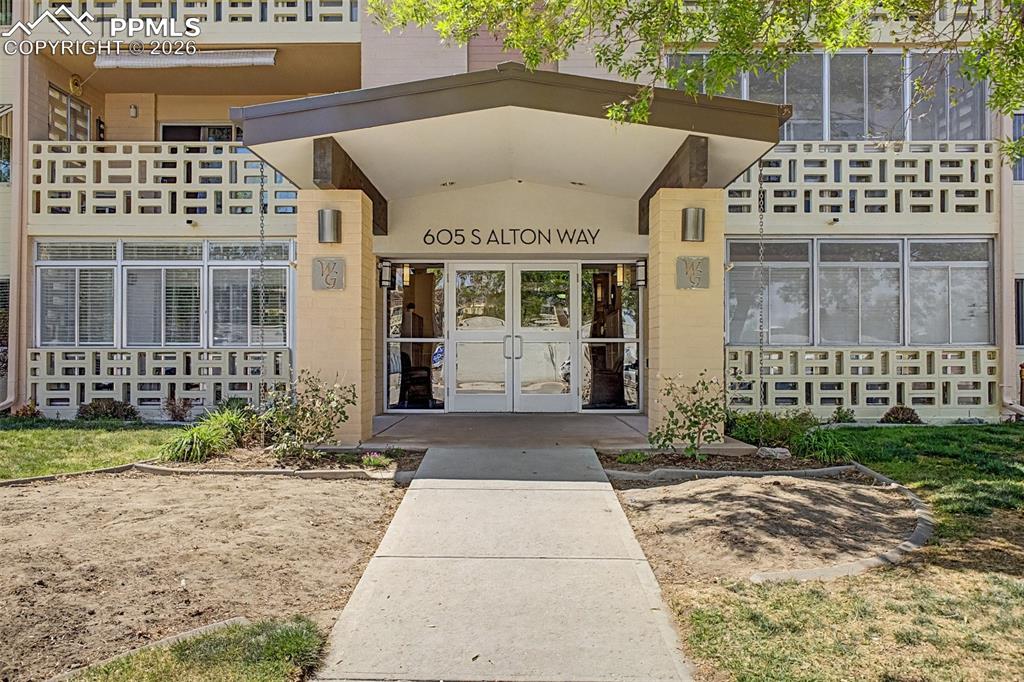 Image 4 of 42: Building entrance featuring an overhead canopy, double glass doors, and ext
