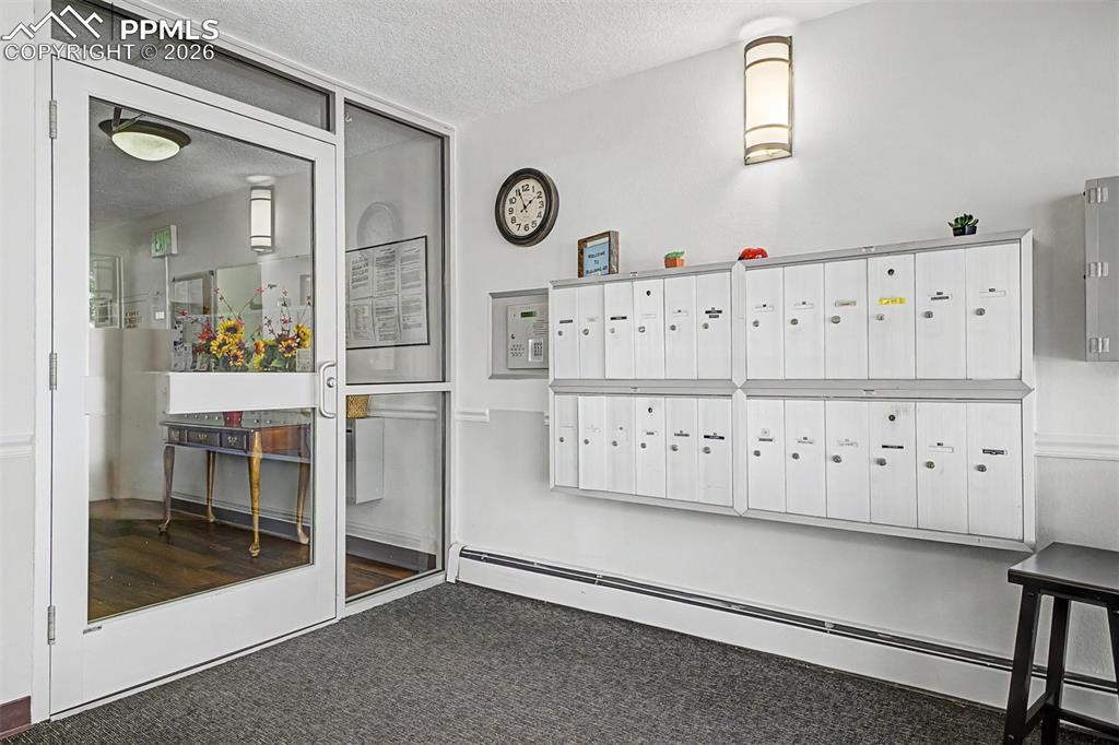 Image 6 of 42: Entryway featuring secured mailboxes and a glass-paneled access door