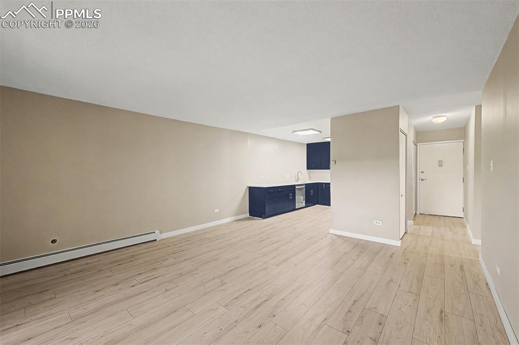 Image 8 of 42: Expansive living area featuring light wood-finish flooring, neutral wall to