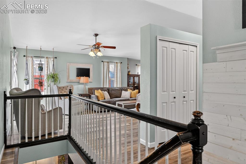 Image 11 of 47: Stairway featuring a ceiling fan and wood finished floors