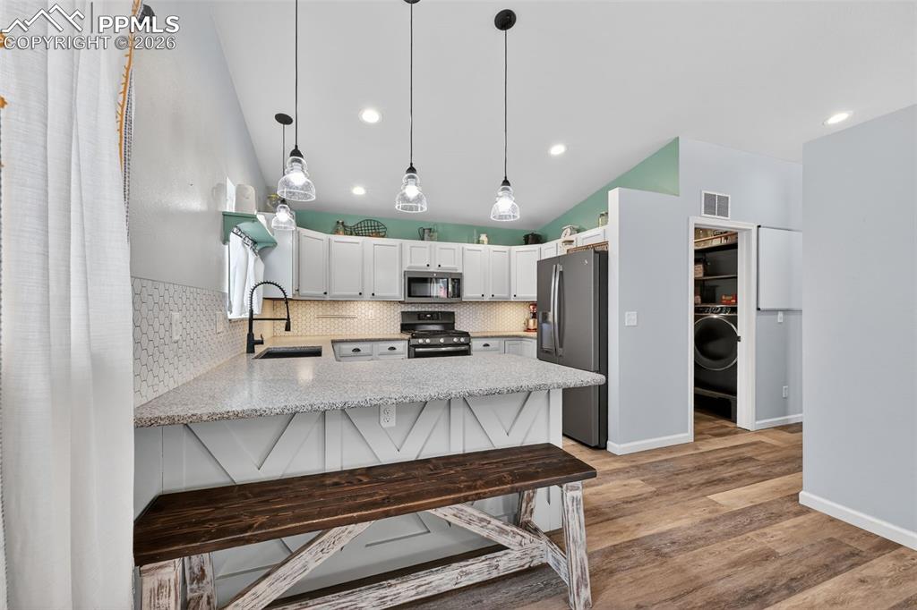 Image 18 of 47: Kitchen with a breakfast bar area, appliances with stainless steel finishes