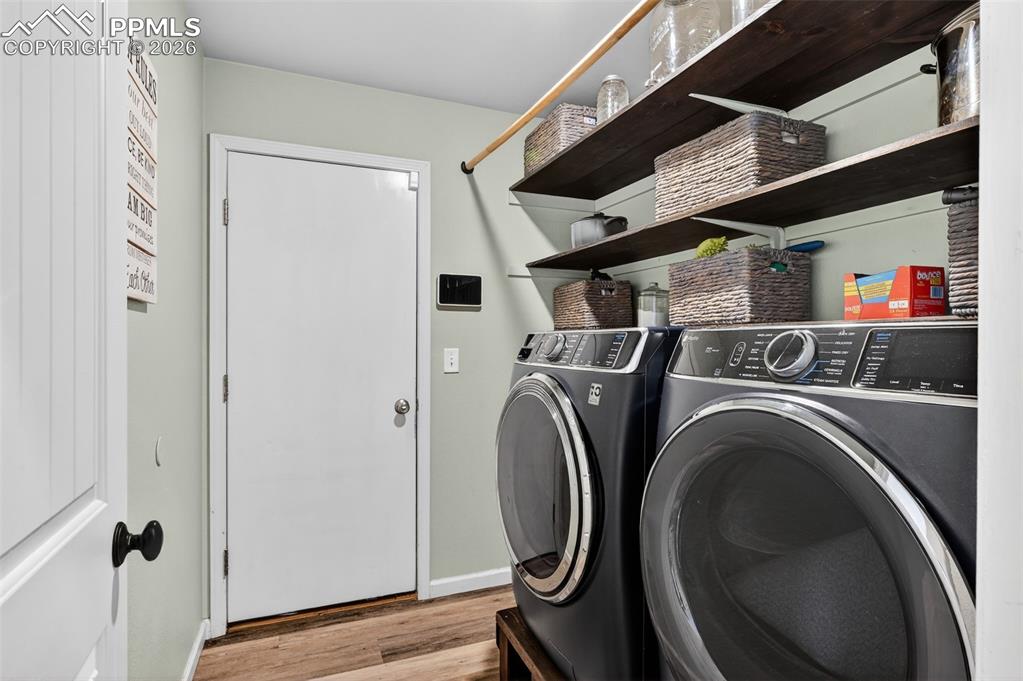 Image 21 of 47: Washroom with light wood finished floors and washer and dryer