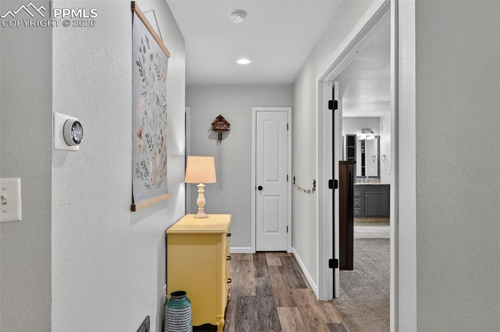 Image 22 of 47: Hallway featuring wood finished floors, a textured wall, and recessed light