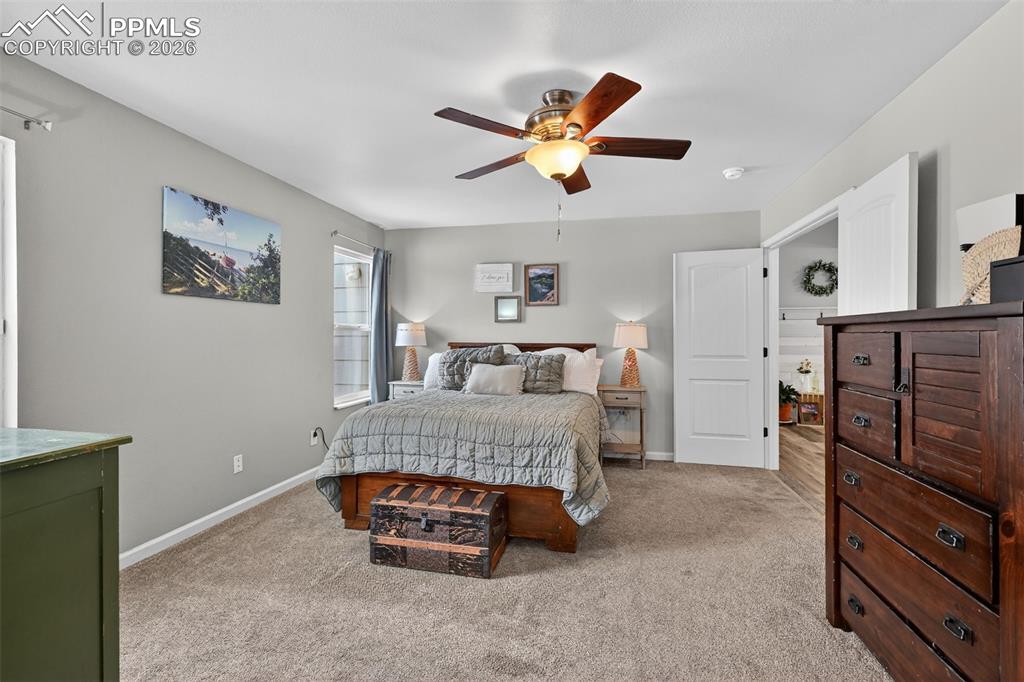 Image 26 of 47: Bedroom with light colored carpet and ceiling fan