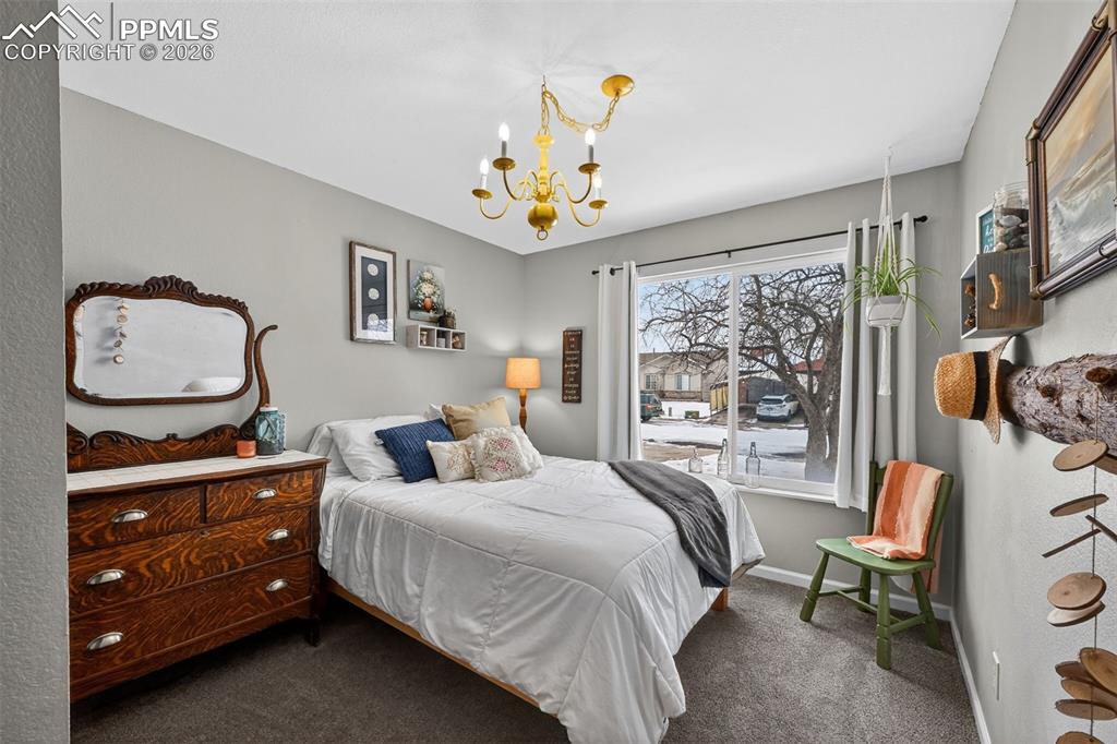 Image 28 of 47: Carpeted bedroom featuring a chandelier and baseboards
