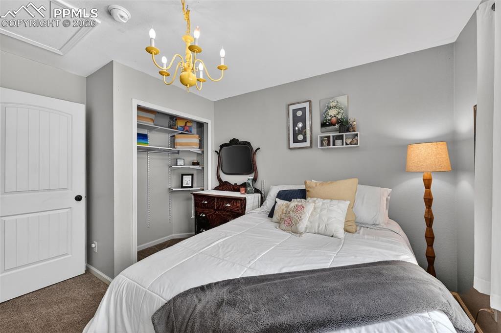 Image 29 of 47: Carpeted bedroom featuring a closet and a chandelier