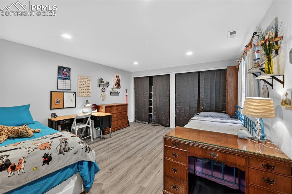Image 39 of 47: Bedroom with multiple closets, light wood finished floors, and recessed lig