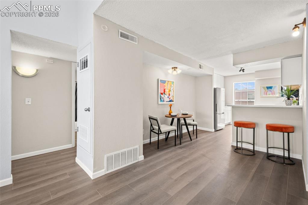 Image 11 of 27: Living room featuring wood-look flooring, light-colored walls, and an overh