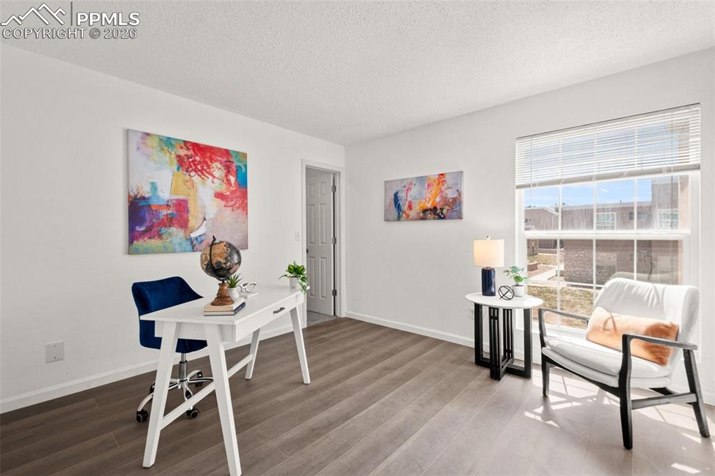 Image 18 of 27: This versatile room features light-colored walls and wood-look flooring, pr