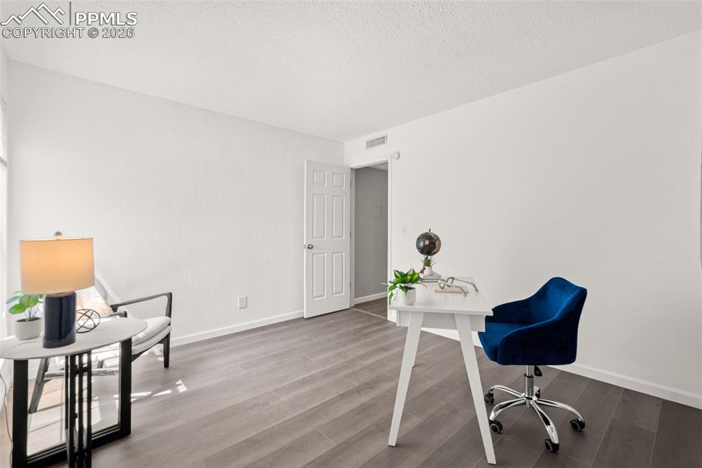 Image 19 of 27: The property features light-colored walls and wood-style flooring, creating