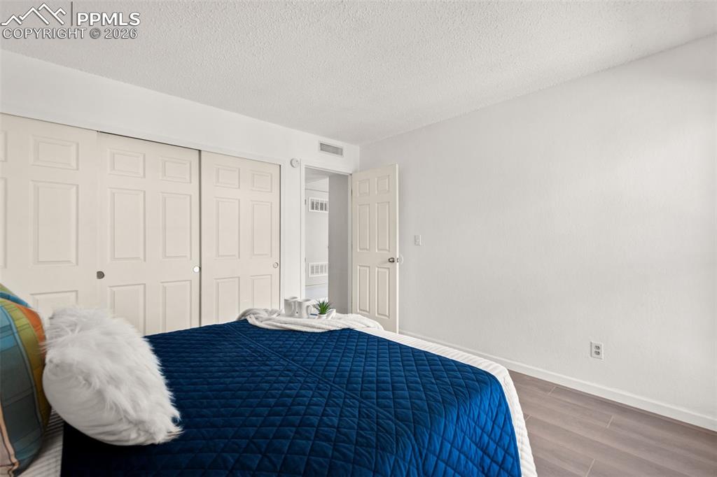 Image 23 of 27: The room features light-colored walls and flooring, with a closet that has 