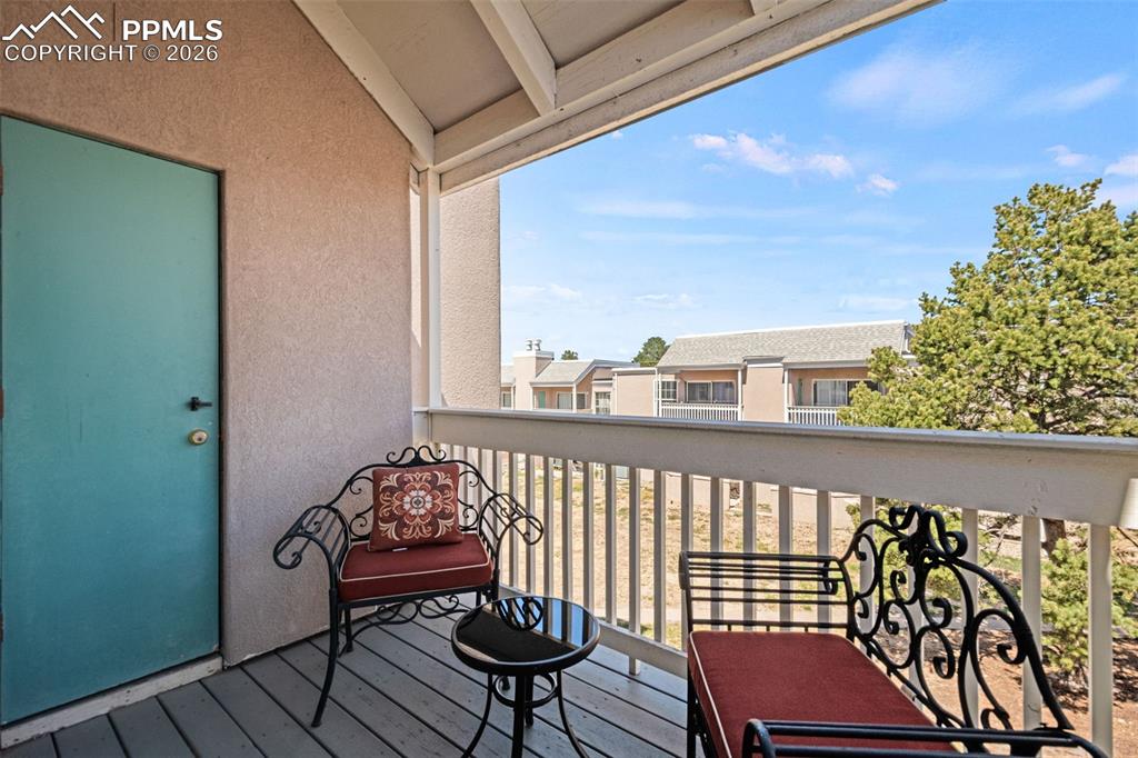 Image 24 of 27: The property features a balcony with a wooden floor and a white railing, of