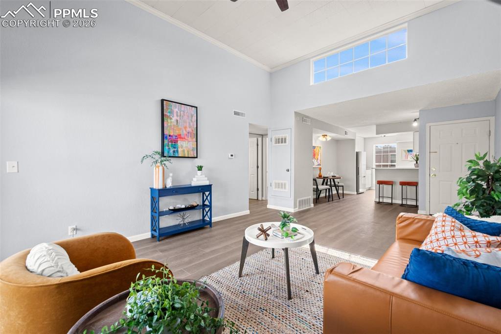 Image 7 of 27: The living area features high ceilings with a transom window, wood-look flo