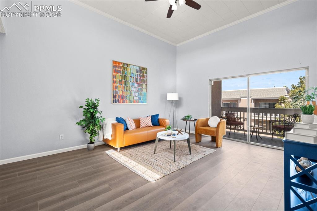 Image 9 of 27: Living area featuring dark wood-look flooring, high ceilings with a ceiling