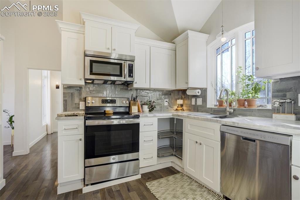 Image 12 of 35: Remodeled kitchen with stacked cabinetry & custom backsplash.