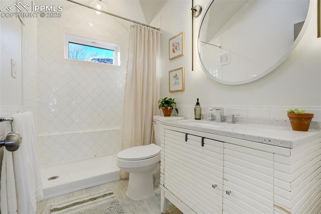 Image 18 of 35: Main level bathroom with walk-in shower.