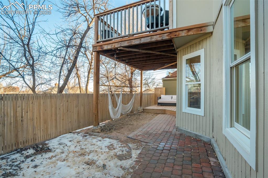 Image 28 of 35: Lower patio area with new fence around the property.