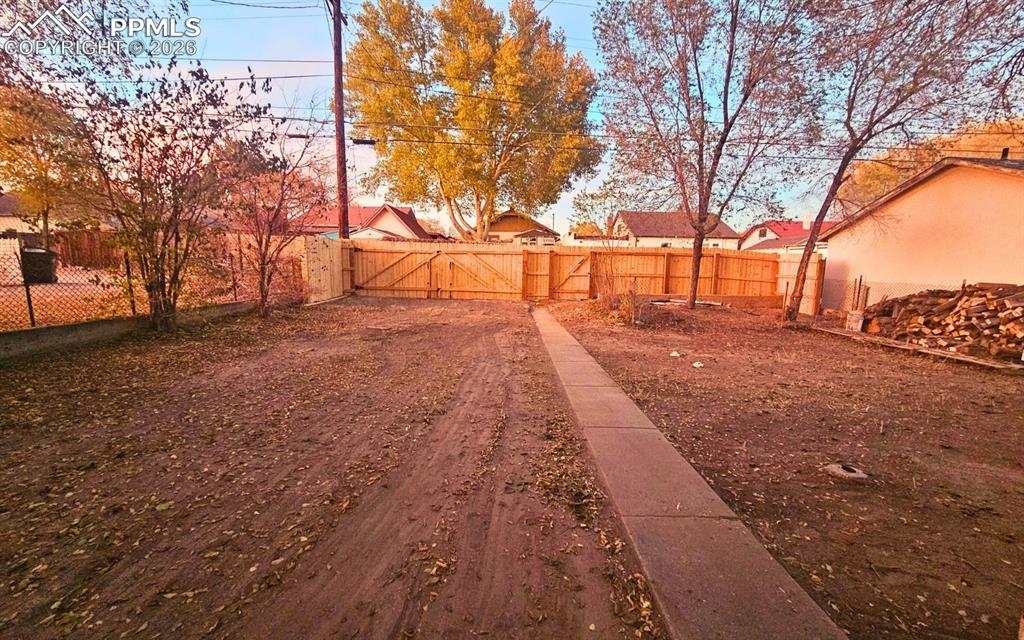 Image 19 of 28: Large yard and cedar fencing with swing door, and man door