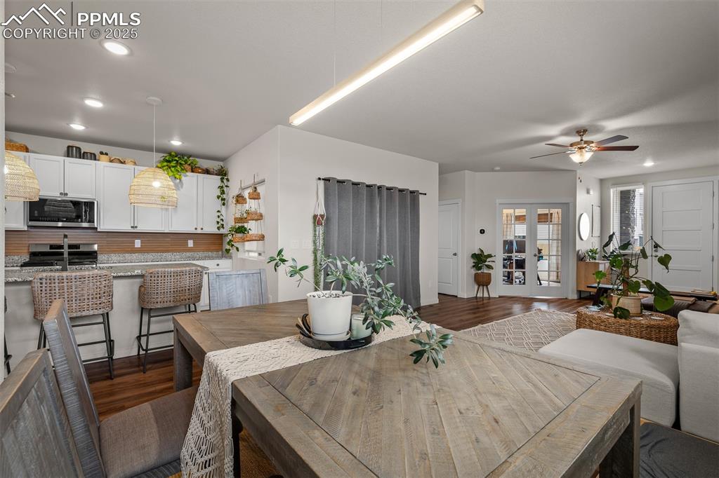 Image 11 of 49: Dining room featuring dark wood finished floors, a ceiling fan, and recesse