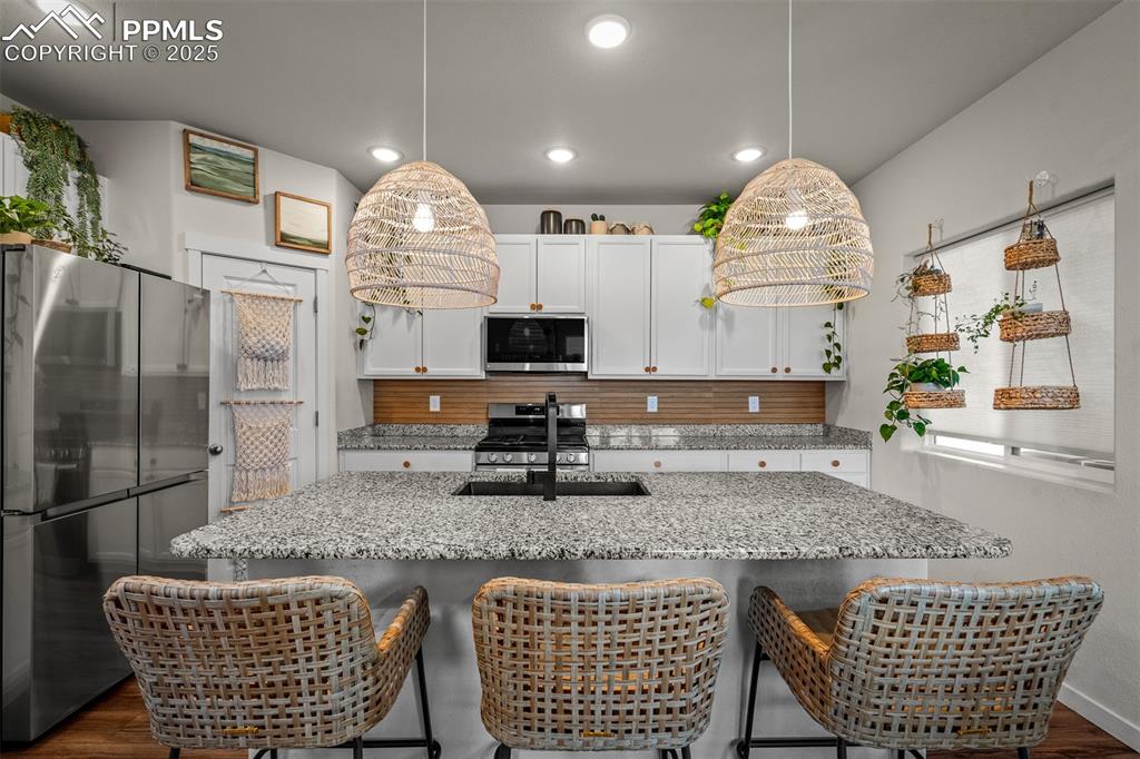 Image 13 of 49: Kitchen featuring appliances with stainless steel finishes, backsplash, a s