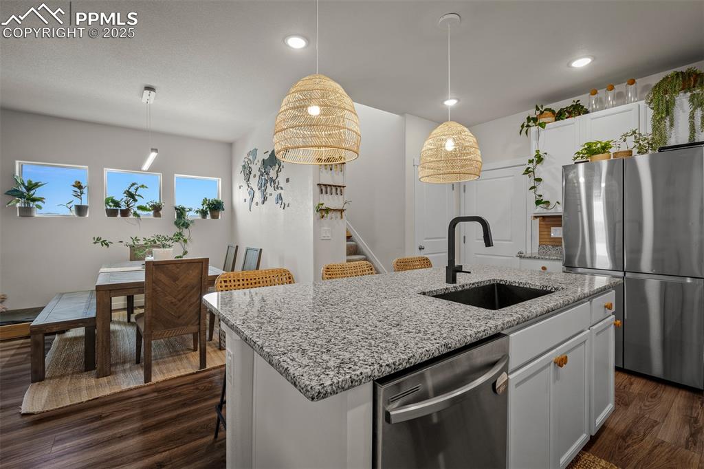 Image 17 of 49: Kitchen featuring appliances with stainless steel finishes, a sink, dark wo